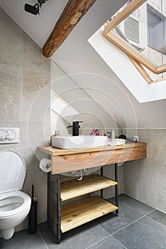 Attic apartment, modern bathroom, apartment interior design with old rustic wooden beams and furniture, stylish Italian granite photo