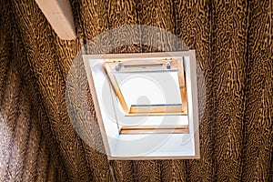 In the attic an apartment. Small window applied to the sloped ceiling