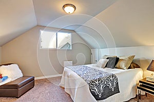 Attic bedroom with large bed and carpet floor.