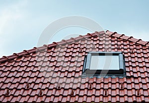 Attic skylight window on red ceramic tiles house roof outdoor. Attic Skylights Home Design Ideas Exterior. photo