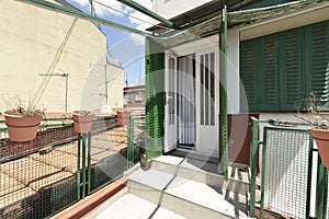 Attic terrace with green metal latticework, clay pots and views photo