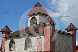 Attic of a white brick private house with windows and red towers