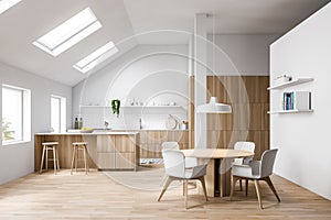 Attic white kitchen with bar and dining table