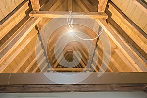 Attic, wooden beams in old loft ,roof before construction with lights on