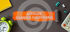 Attitude Changes Everything - text appearing behind torn brown paper. Motivation quote