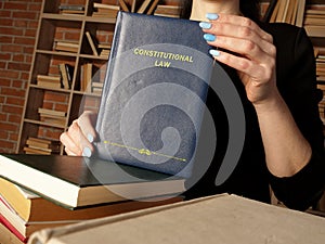 Attorney holds CONSTITUTIONAL LAW book. Constitutional law, the body of rules, doctrines, and practices that govern the operation