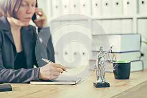 Attorney woman talking on mobile phone from her office desk