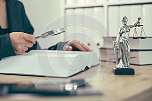 Attorney woman using magnifying glass for law book reading