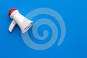 Attract attention concept. Megaphone on blue background top view copy space