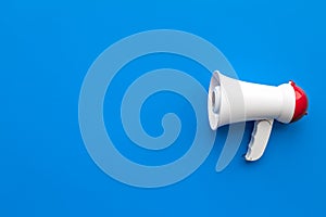 Attract attention concept. Megaphone on blue background top view copy space