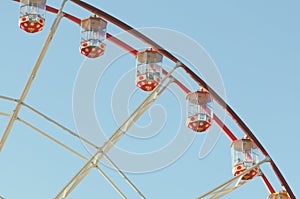 An attraction of a Ferris wheel against a blue sky background.