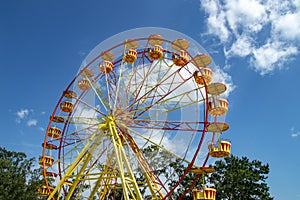 Attraction ferris wheel with red and eyllow booths