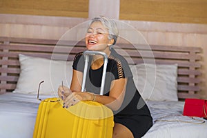 Attractive 40s to 50s mature Asian tourist woman with grey hair arriving in hotel room excited smiling  cheerful enjoying business