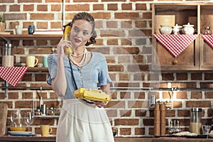 attractive adult housewife talking by vintage rotary phone