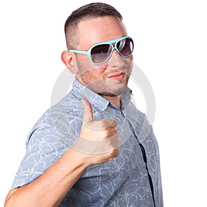 Attractive adult man with beard wearing sunglasses in summer shirt shows the gesture OK