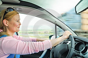 Attractive adult woman safe carefully driving car suburban road