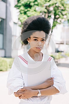 attractive african american businesswoman standing on street