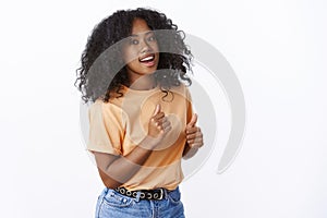 Attractive african-american party girl dancing near white background. Cute young college student having fun moving