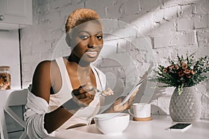 Attractive african american woman holding newspaper and