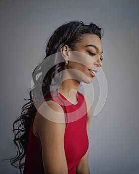 Attractive african american woman wearing red dress against grey background