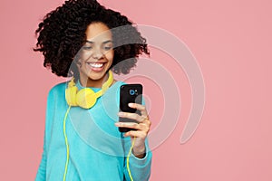 Attractive african american young woman with bright smile dressed in casual clothes take picture with smartphone over