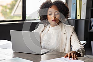 Attractive african lady in formal outfit working on marketing report
