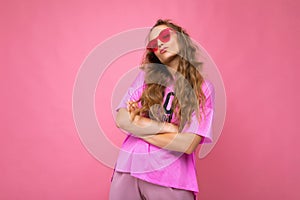 Attractive amusing upset young blonde woman wearing everyday stylish clothes and modern sunglasses  on colorful