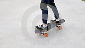 Attractive Asian boy with safety skateboarding knee pad skating at skateboard park.