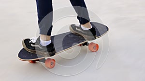 Attractive Asian boy with safety skateboarding knee pad skating at skateboard park.