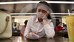 Attractive Asian Businesswoman boring, see clock, waiting in one restaurant