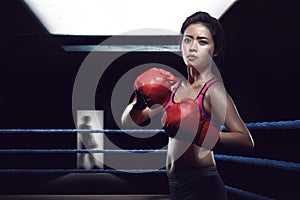 Attractive asian female boxer in boxing arena