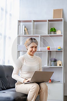 Attractive Asian female business owner in apron with open door sign vertical image