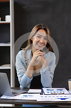 Attractive Asian female business owner in apron with open door sign vertical image