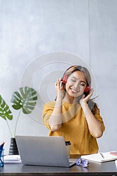 Attractive Asian female business owner in apron with open door sign vertical image