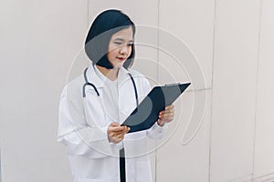 An attractive Asian female doctor in white coat with a black stethoscope