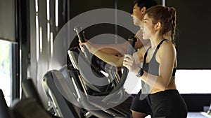 Attractive Asian fitness woman using elliptical trainer at the gym. Healthy and weight loss lifestyle