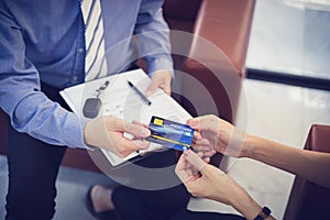 Attractive Asian girl millenials buying a new car with credit card. Film effected