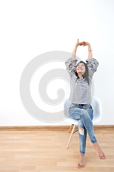 Attractive Asian girl sitting on white modern chair