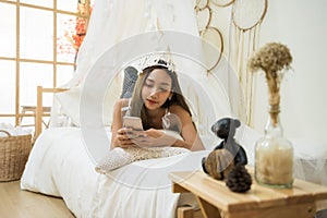 Asian girl play smartphone on bed