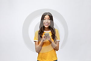 Attractive Asian teenage girl looking at her mobile phone screen with joyful face, on white background for copy space.