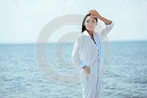 attractive asian woman with hand in pocket looking away in front of