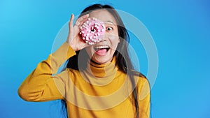 Attractive asian woman having fun with donut