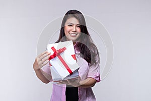 Attractive Asian woman holding gift box in Christmas, new year, valentine day, birthday celebration concept. Portrait of smiling