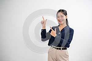 Attractive Asian woman is pointing her index fingers up to an empty space, white studio background