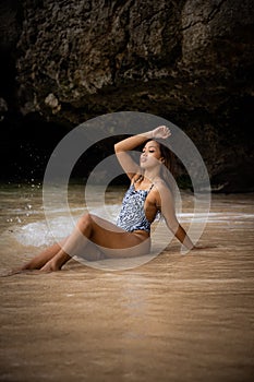 Attractive Asian woman posing by the sea. Spend time on the beach. Sexy body. Tanned skin. Tropical island travel concept. Summer