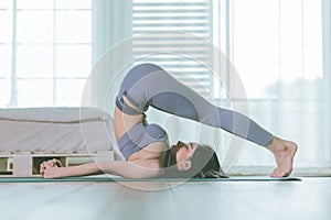 Attractive Asian woman practice yoga in bedroom after wake up in the morning