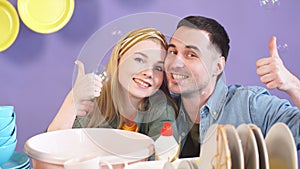 Attractive awesome young couple showing thumbs up while looking at camera
