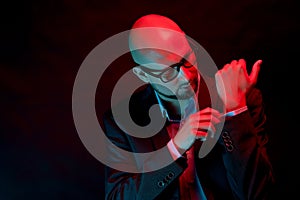 Attractive bald man with beard with glasses on neon light background