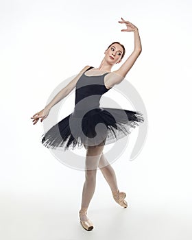 Attractive ballerina stands on her fingertips. photo shoot in the studio on a white background
