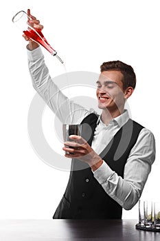 An attractive bartender at a bar counter doing a cocktail, a plate of lime isolated on a white background.